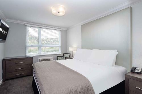 基洛纳基洛纳桑德曼套房酒店的卧室设有一张白色大床和一扇窗户。