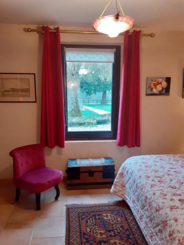 La PuisayeLa PASTORALE的一间卧室设有一张床、一个窗口和一把椅子