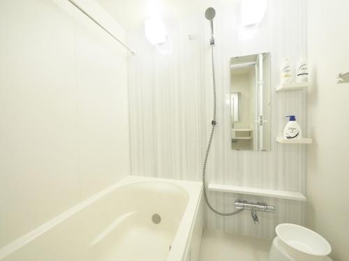 Chikusachōケイアイコンホテルズ ふくしあ801的白色的浴室设有浴缸和卫生间。