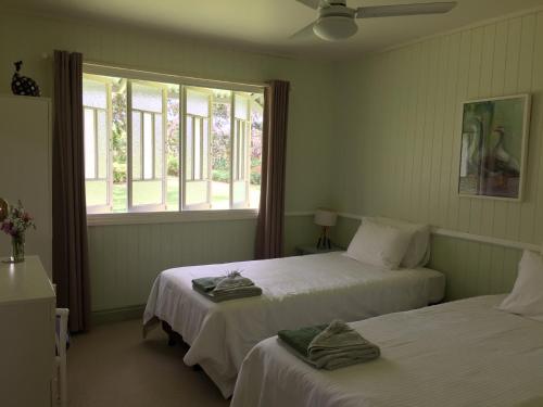 金皮CedarBrae Country Stay的一间卧室设有两张床,窗户配有毛巾。