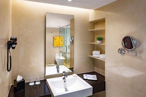 峇六拜颐思殿的一间带水槽、镜子和卫生间的浴室