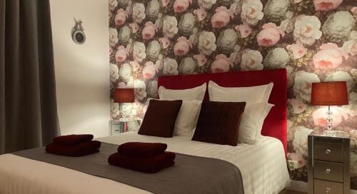 ÉvranLe Patio的一间卧室设有一张带花卉墙壁的大床