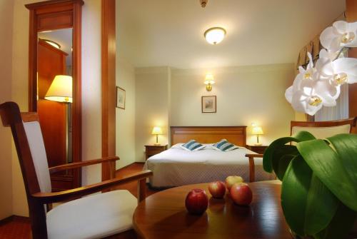 桑多梅日巴茨托维酒店的一间卧室配有一张床和一张桌子,上面有苹果
