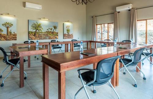 纳姆比提动物保护区Lions Valley Lodge的一间会议室,配有木桌和椅子