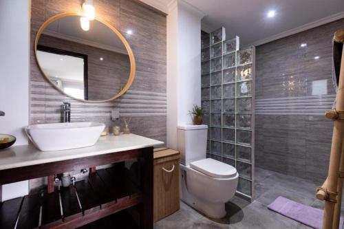 博瓦隆Peponi SelfCatering Apartments的一间带水槽、卫生间和镜子的浴室