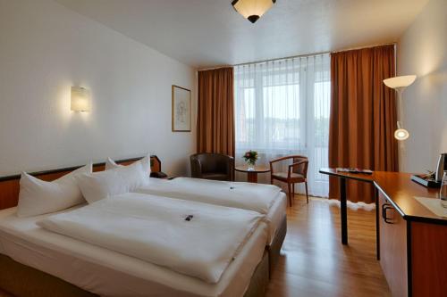 柏林附近贝尔瑙贝尔瑙舒适酒店的酒店客房设有一张大床和一张书桌。