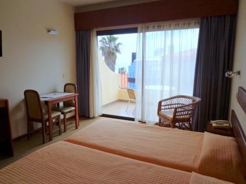 卡尼索维拉文图拉酒店的酒店客房带一张床、一张桌子和椅子