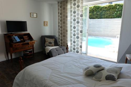 佩皮尼昂Très bel appartement (40m²) avec piscine privative的一间卧室设有一张床、一台电视和一个窗口。