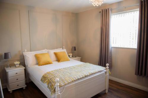 邓格洛The Chalet town centre的一间卧室配有一张带黄色枕头的床和一扇窗户