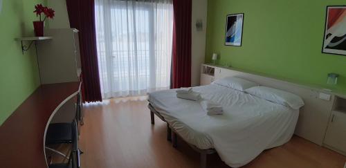 塞斯特雷拉戈罗塞特酒店的一间位于绿色客房内的带白色床的卧室