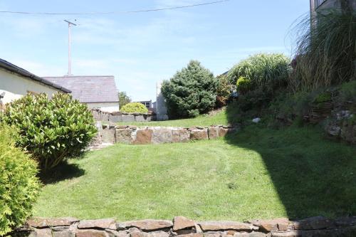 斯旺西The Granary的一座带石墙和庭院的花园