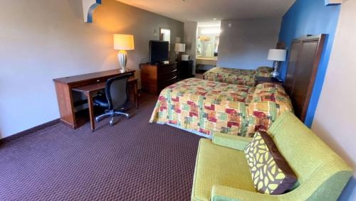 玛丽埃塔市Magnuson Hotel Marietta的酒店客房设有一间带一张床和一张书桌的卧室