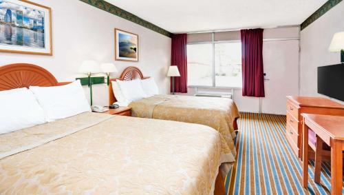 杰克逊维尔Magnuson Hotel Jacksonville Downtown的酒店客房设有两张床和一台平面电视。