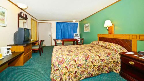 CovingtonM Star Hotel Covington的配有一张床和一台平面电视的酒店客房