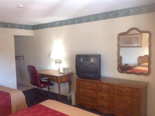纽黑文纽黑文酒店的酒店的客房配有电视和带镜子的书桌