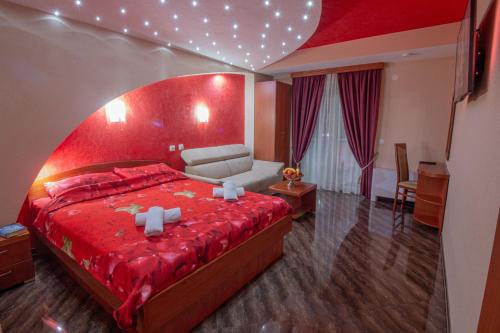 奥赫里德迪斯利维斯基别墅的一间卧室配有一张红色的大床和一张沙发