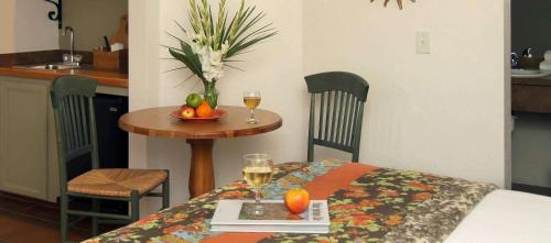 棕榈泉加利福尼亚酒店的一张桌子,上面放着一碗水果和两杯葡萄酒