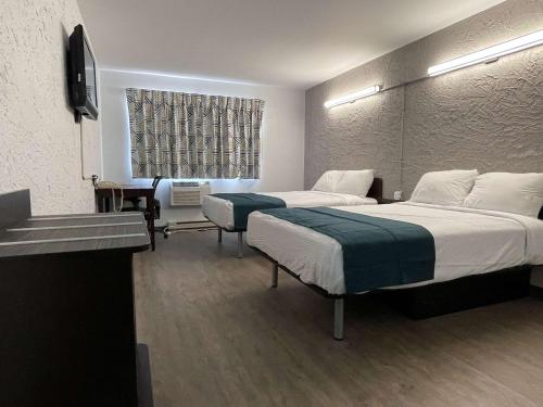 绿湾格林贝朗博6号汽车旅馆的酒店客房设有两张床和窗户。