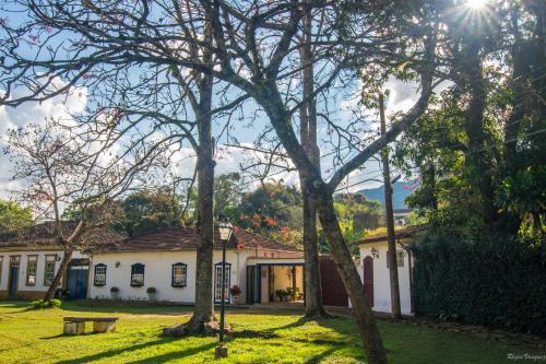 蒂拉登特斯Casa de Violeta Pousada的前面有树木的房子