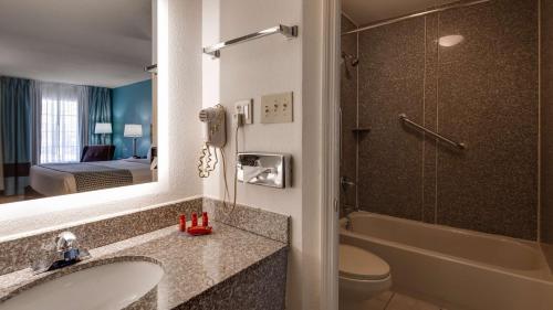 阿什伯勒SureStay Plus Hotel by Best Western Asheboro的一间带水槽和卫生间的浴室以及一部电话