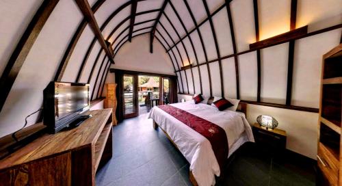 吉利阿尔Oceans 5 Dive Resort的一间卧室配有一张床和一台电视。