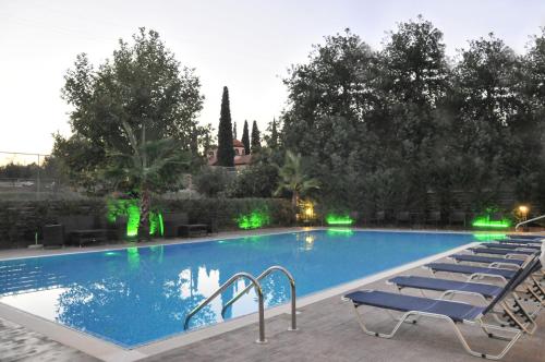 卢特拉伊帕蒂斯埃纳酒店的旁边设有一座带躺椅的大型游泳池