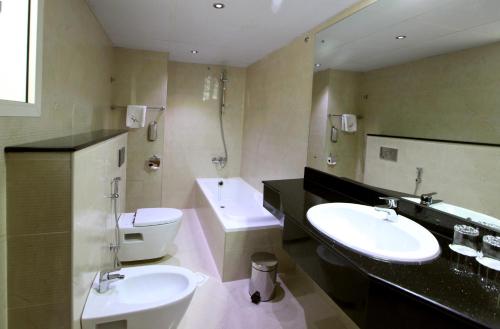 迪拜Gulf Inn Hotel Deira Formerly City Star Hotel的浴室配有2个盥洗盆、卫生间和浴缸。
