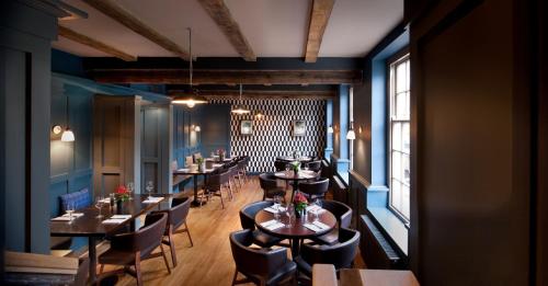 阿宾登王冠与蓟酒店的一间设有桌椅的餐厅,位于拥有蓝色墙壁的房间