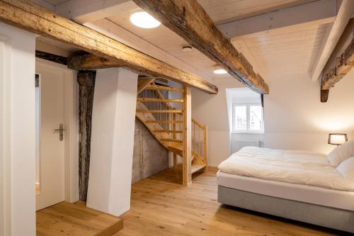 吕讷堡Michaelis Suite - Schrangen-Suites-1389的一间卧室设有一张床和木制楼梯。