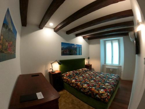 莱科La Casa sul Lago Lecco 2的一间卧室配有一张床、一张桌子和一个窗户。