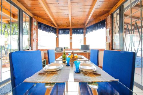 巴勒莫Villa Rosa Bianca的一间带桌子和蓝色椅子的用餐室
