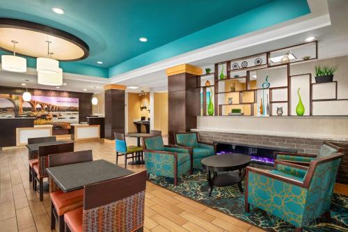 中洛锡安La Quinta Inn & Suites by Wyndham Richmond-Midlothian的一间带桌椅的餐厅和一间酒吧