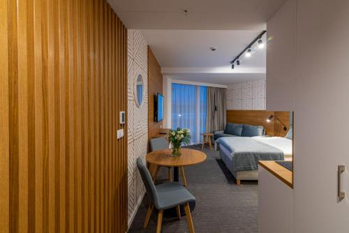 科沃布热格Seaside Apartaments Deluxe 627的酒店客房设有一张床铺、一张桌子和一间卧室。