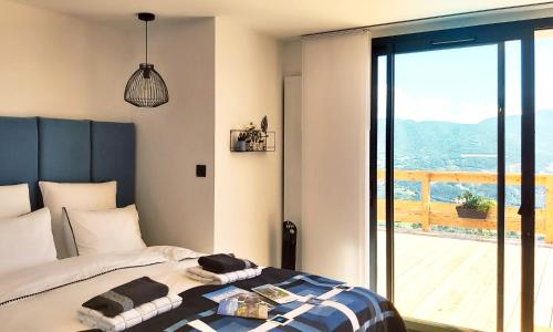 新拉巴蒂Katsoleil的一间卧室设有一张床和一个大型玻璃窗