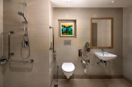 阿格拉Holiday Inn Agra MG Road an IHG Hotel的浴室配有卫生间、盥洗盆和淋浴。