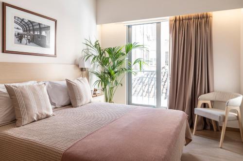 比雷埃夫斯Gallery Suites & Residences的一间卧室设有一张床和一个滑动玻璃门