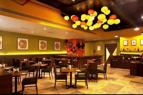 纳威孟买Hotel Mumbai House Airoli, Navi Mumbai的一间带桌椅的用餐室和一间餐厅