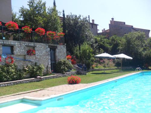 Vallo di Nera罗卡加丽农庄的一座带房子的建筑前的游泳池