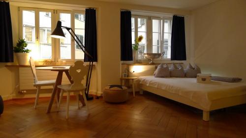 苏黎世Signature Bijou的卧室配有床、桌子和窗户。