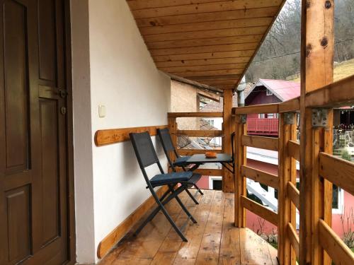 锡吉什瓦拉Toni Apartment的木制甲板上的阳台配有两把椅子