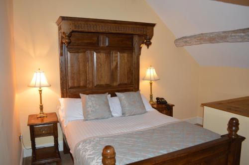 Mallwyd布里根茨宾馆的一间卧室配有一张带木制床头板的床和两盏灯。