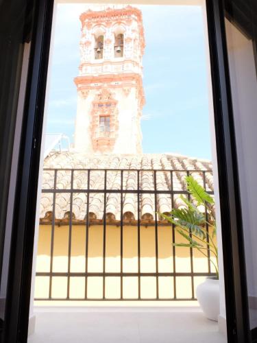 埃希哈Los Balcones Largos的享有带钟楼建筑的窗户景致