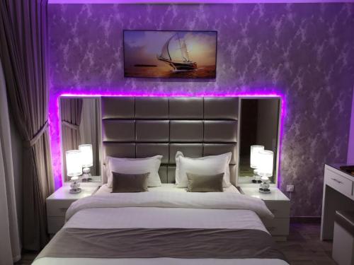 利雅德Makarem Hotel Apartment的一间卧室配有一张紫色照明的大床