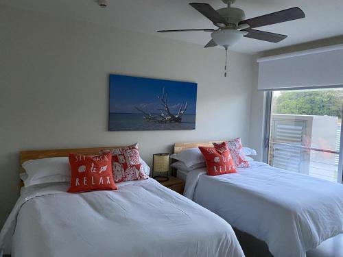 普拉纳维瑙Azuero Lodge: Luxury Beachfront condo- Playa Venao的一间卧室配有两张床和吊扇