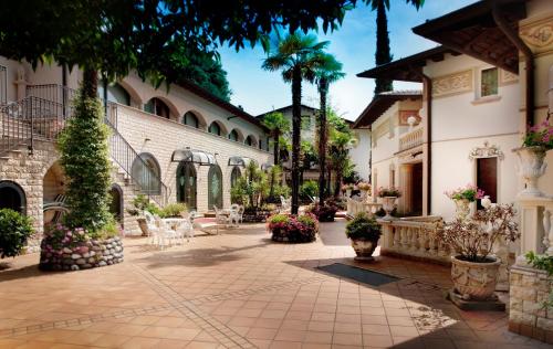 加尔多内-里维耶拉Park Hotel Ville Montefiori的花卉和植物的建筑的庭院