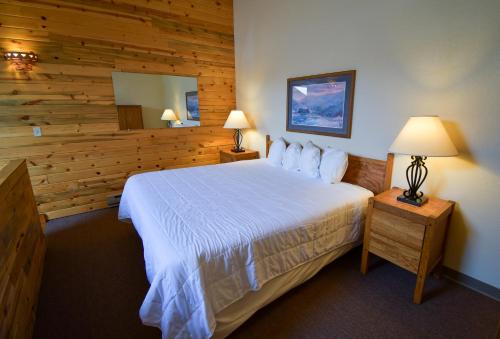 格兰比银溪酒店的一间卧室设有一张床和木墙