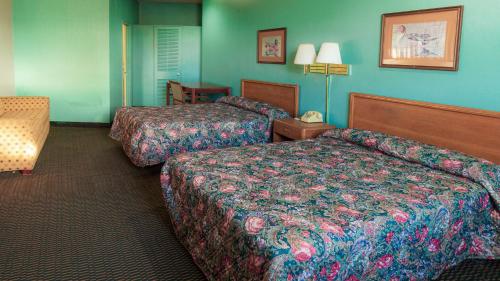 代顿Red Horse Motel Dayton Moraine的两张位于酒店客房的床,拥有蓝色的墙壁