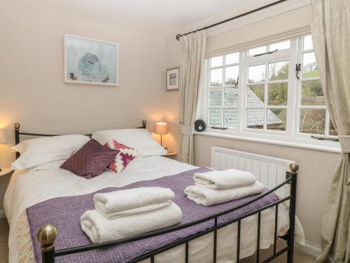 巴德利索尔特顿Robyn Cottage的一间卧室配有带毛巾的床
