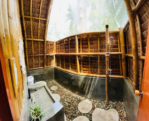 莫阿尔博阿MAAYONG HOSTEL的一间带浴缸的浴室,位于竹屋内