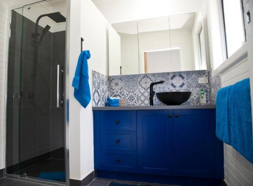 TyennaTyenna River Cottages的蓝色的浴室设有水槽和淋浴